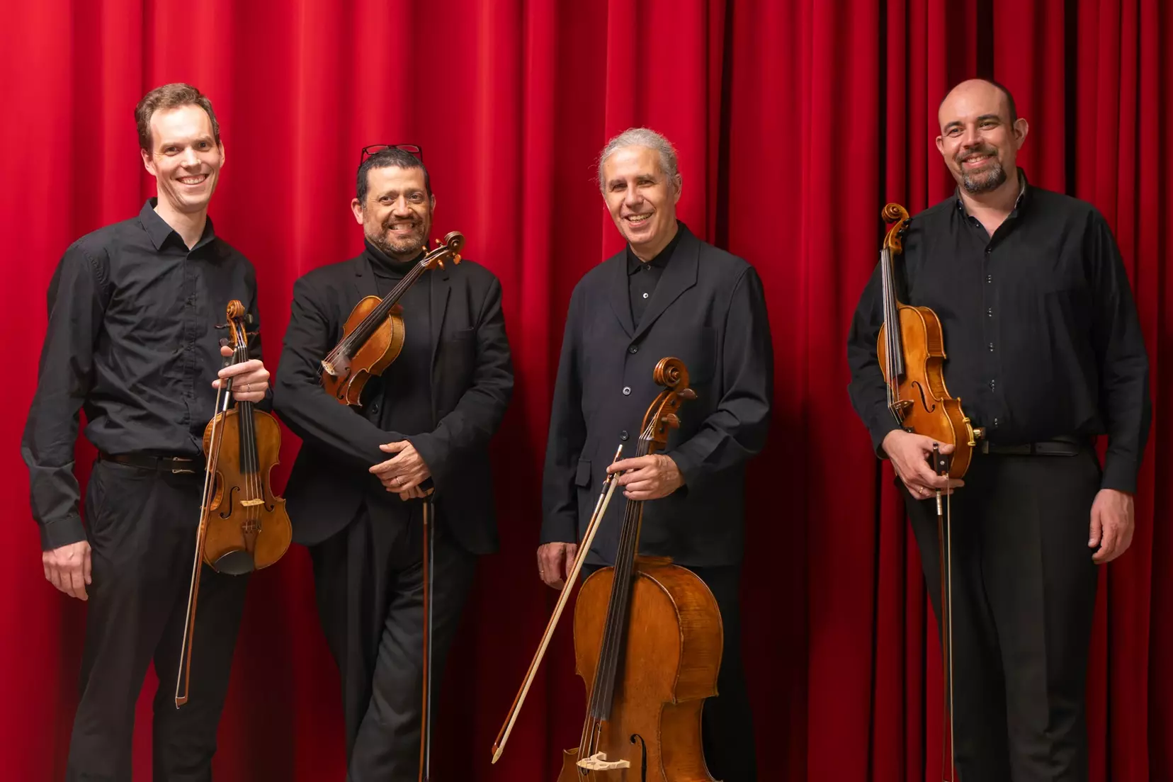 photo du quatuor devant un rideau rouge