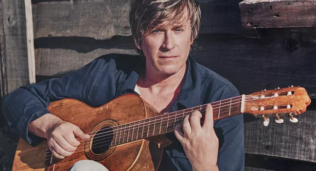 Photo de Thomas Dutronc posant avec sa guitare