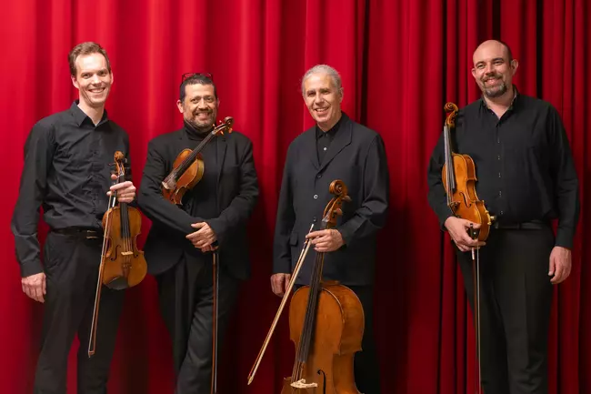 photo du quatuor devant un rideau rouge