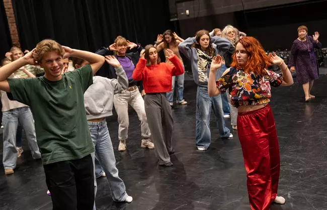 personnes de tous âges en train de suivre une initiation de danse avant un spectacle