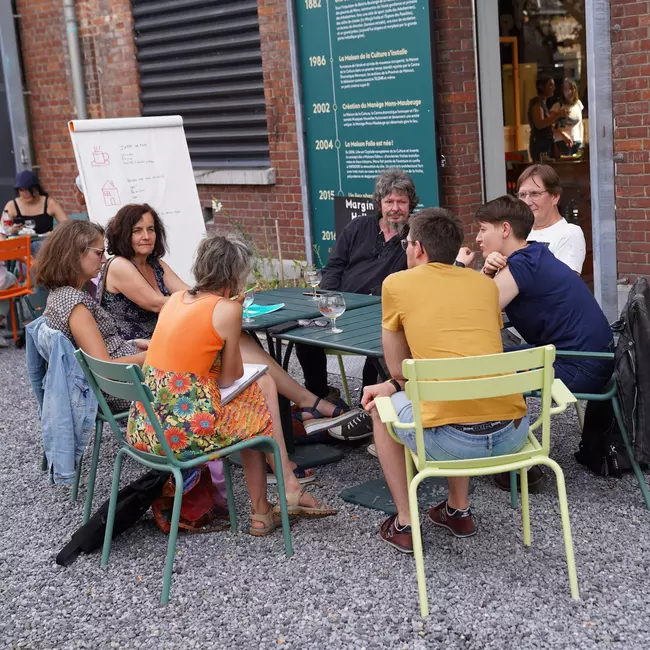 Citoyens et citoyennes de la maison folie en consultation autour d'une table pour construire le projet ensemble