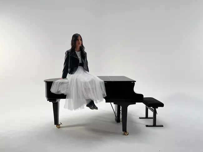 Sarina assise sur un piano