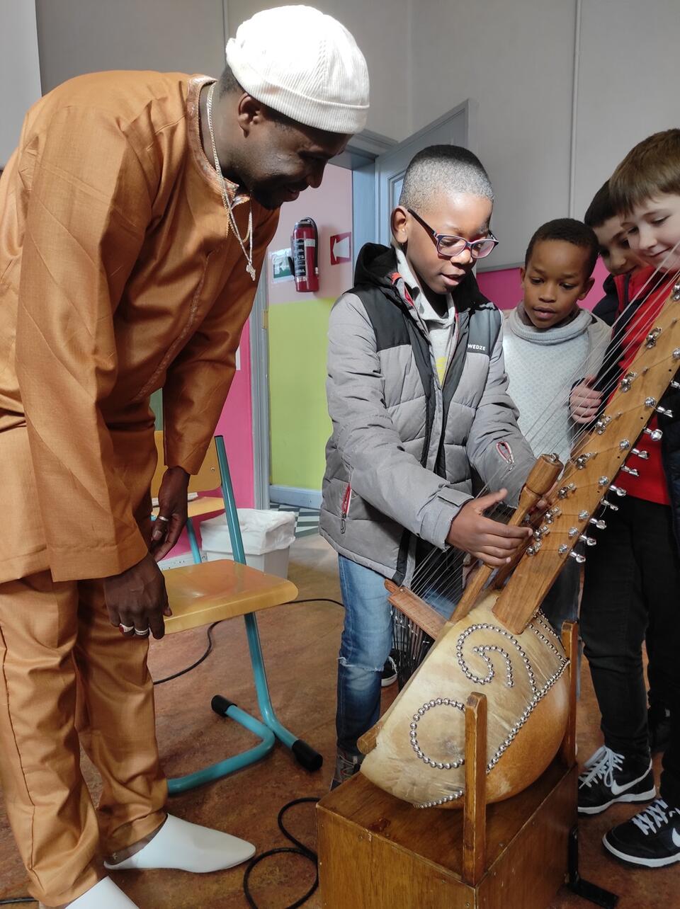 enfant qui joue d'un instrument de musique africain