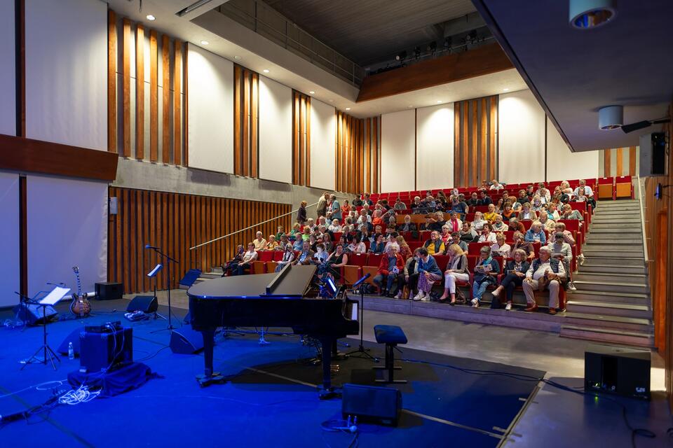 photo du gradin de la salle d'Arsonic avec en premier plan un piano puis en arrière plan le public assis