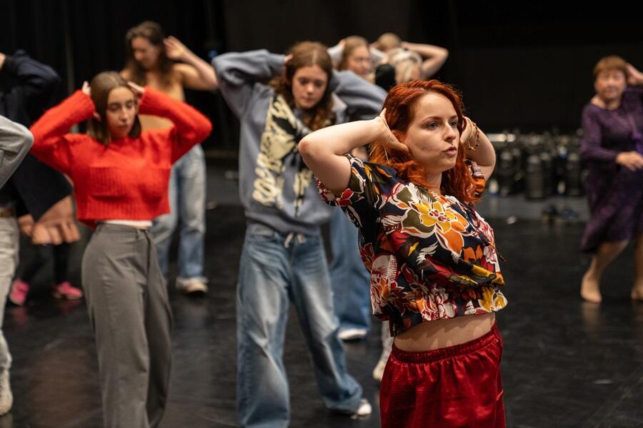 personnes de tous âges en train de suivre une initiation de danse avant un spectacle