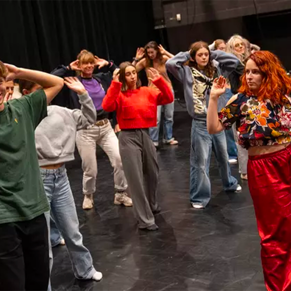 Personnes de tous âges en train de suivre une initiation de danse avant un spectacle