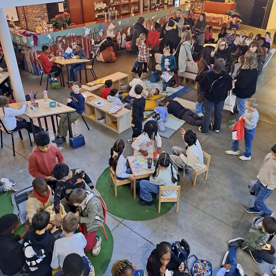 Enfants autour de tables pendant des ateliers créatifs